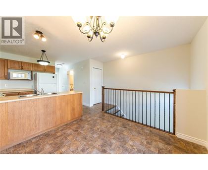 A well-lit kitchen area with a wooden countertop and a chandelier.