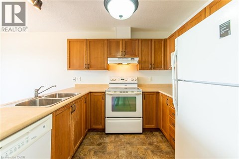 A kitchen with wooden cabinets and a white stove top oven.