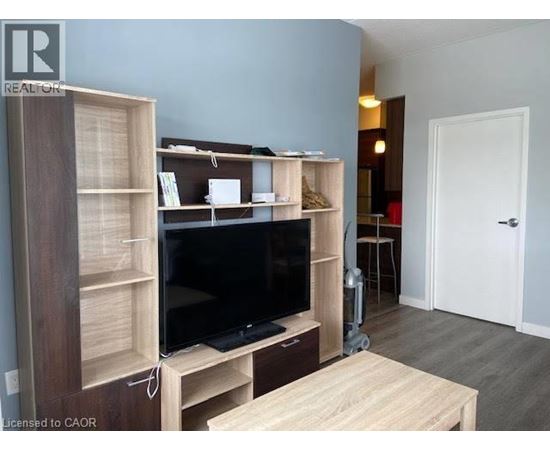 A living room with a television and a wooden cabinet.
