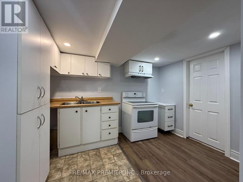 A kitchen with white cabinets and a wooden countertop.
