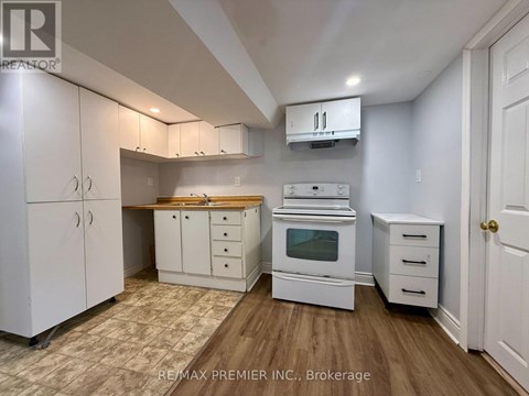 A kitchen with white cabinets and a wooden countertop.