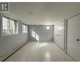 A spacious room with white cabinets and a marble floor.
