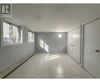 A spacious room with white cabinets and a marble floor.