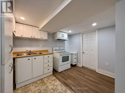 A kitchen with white cabinets and a wooden countertop.
