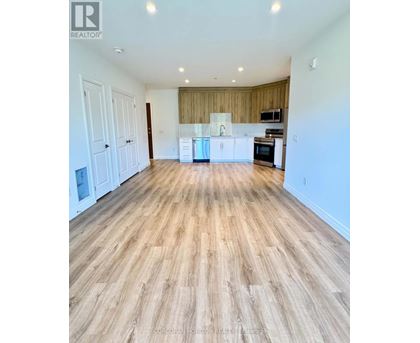 A spacious room with wooden flooring and white walls.