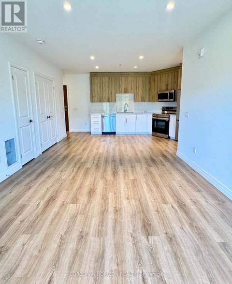 A spacious room with wooden flooring and white walls.