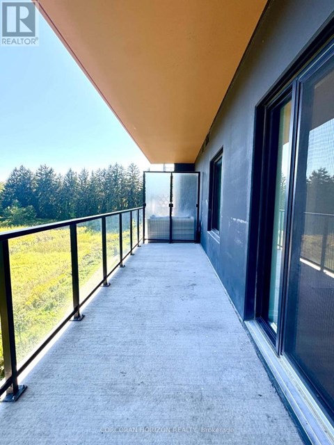 A balcony with a view of trees and a building in the distance.