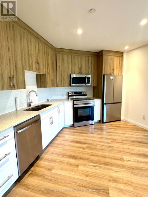 A kitchen with wooden cabinets and stainless steel appliances.