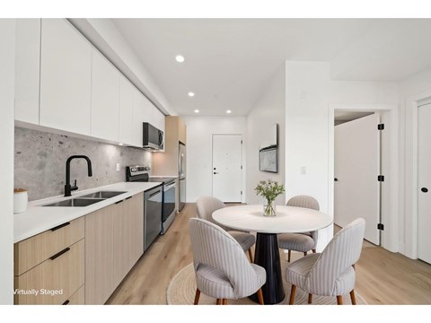 A modern kitchen with a dining table set for four.