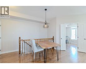 A dining room with a wooden table and chairs.