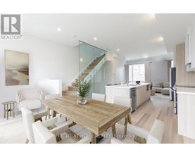A modern dining room with a wooden table and white chairs.