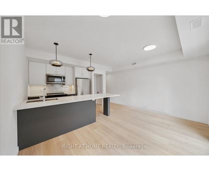 A modern kitchen with a white countertop and a microwave above it.