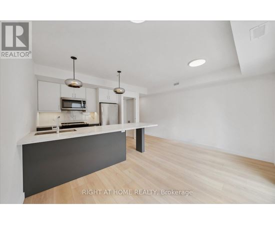 A modern kitchen with a white countertop and a microwave above it.