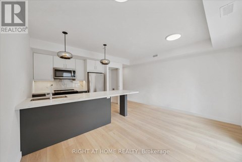 A modern kitchen with a white countertop and a microwave above it.