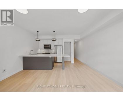 A spacious room with a grey counter and a white chair.