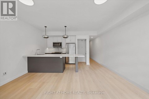 A spacious room with a grey counter and a white chair.