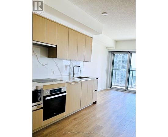 A kitchen with wooden cabinets and black appliances.