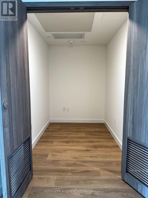 A hallway with a wooden floor and white walls.