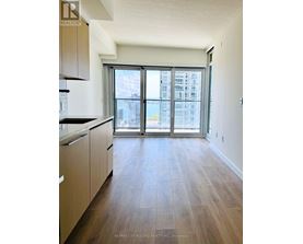 A kitchen with wooden floors and a large window.