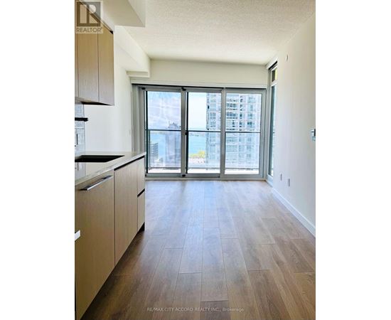 A kitchen with wooden floors and a large window.