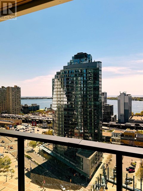 A tall glass building with a view of the water in the background.