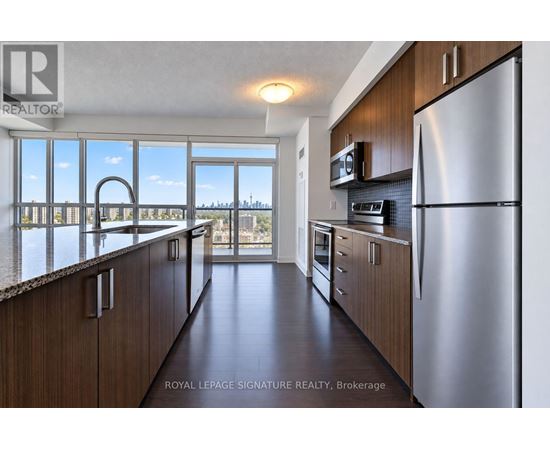 A kitchen with wooden cabinets and a stainless steel refrigerator.
