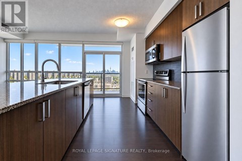 A kitchen with wooden cabinets and a stainless steel refrigerator.