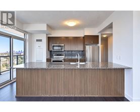 A modern kitchen with wooden cabinets and stainless steel appliances.