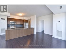 A spacious room with a wooden floor and white walls.
