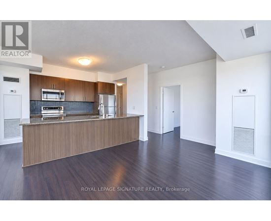 A spacious room with a wooden floor and white walls.