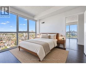 A bedroom with a large bed and a view of the city.