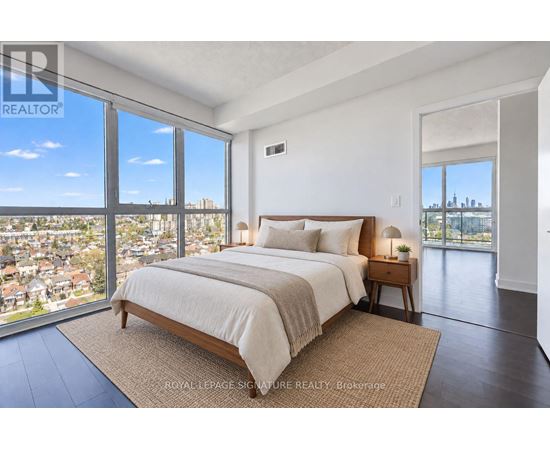 A bedroom with a large bed and a view of the city.