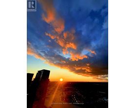 The sun is setting behind the buildings in the city.