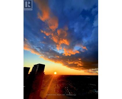 The sun is setting behind the buildings in the city.