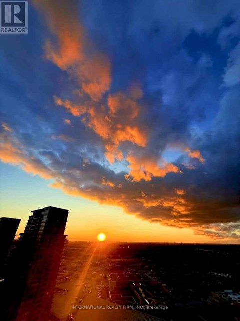 The sun is setting behind the buildings in the city.