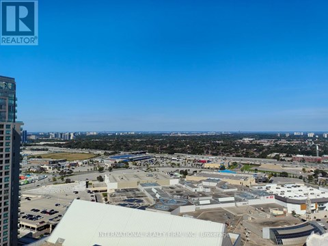 A view of a cityscape with a building in the foreground that has the words "International Realty Firm, Inc." on it.