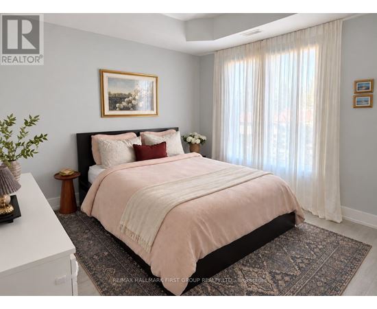 A bedroom with a large bed and a painting on the wall.