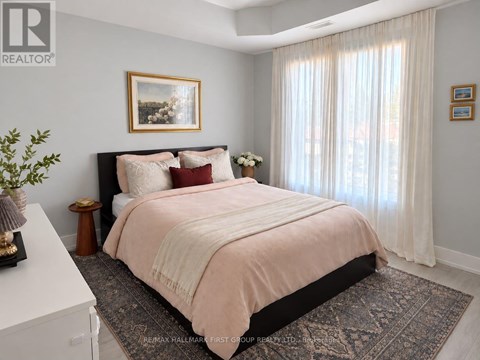 A bedroom with a large bed and a painting on the wall.