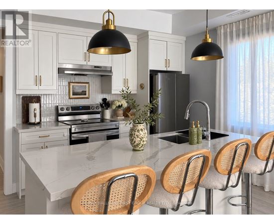 A modern kitchen with a marble countertop and wooden bar stools.