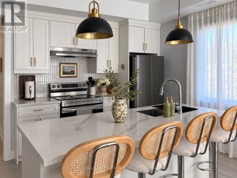 A modern kitchen with a marble countertop and wooden bar stools.