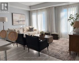 A living room with a white couch, a wooden table, and a rug.