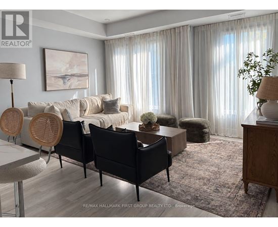 A living room with a white couch, a wooden table, and a rug.