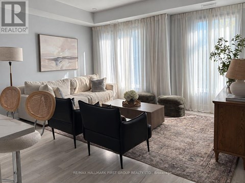A living room with a white couch, a wooden table, and a rug.