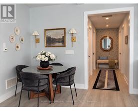 A dining room with a round table and chairs.