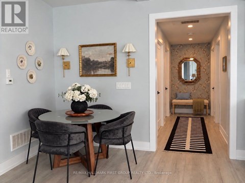 A dining room with a round table and chairs.