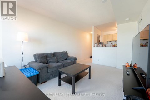 A living room with a grey couch and a black coffee table.
