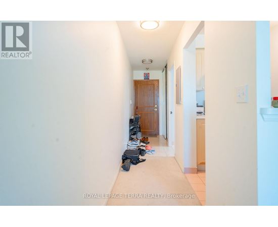 A hallway with a pair of shoes on the floor.