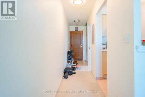 A hallway with a pair of shoes on the floor.