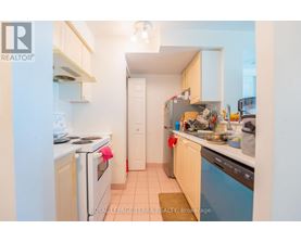 A small, clean kitchen with white appliances and wooden cabinets.