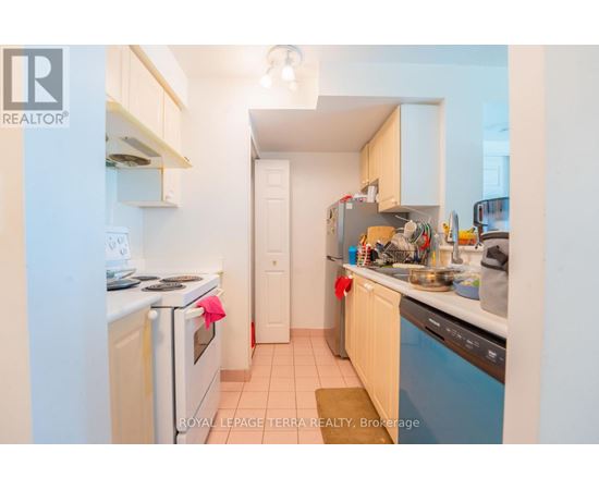 A small, clean kitchen with white appliances and wooden cabinets.
